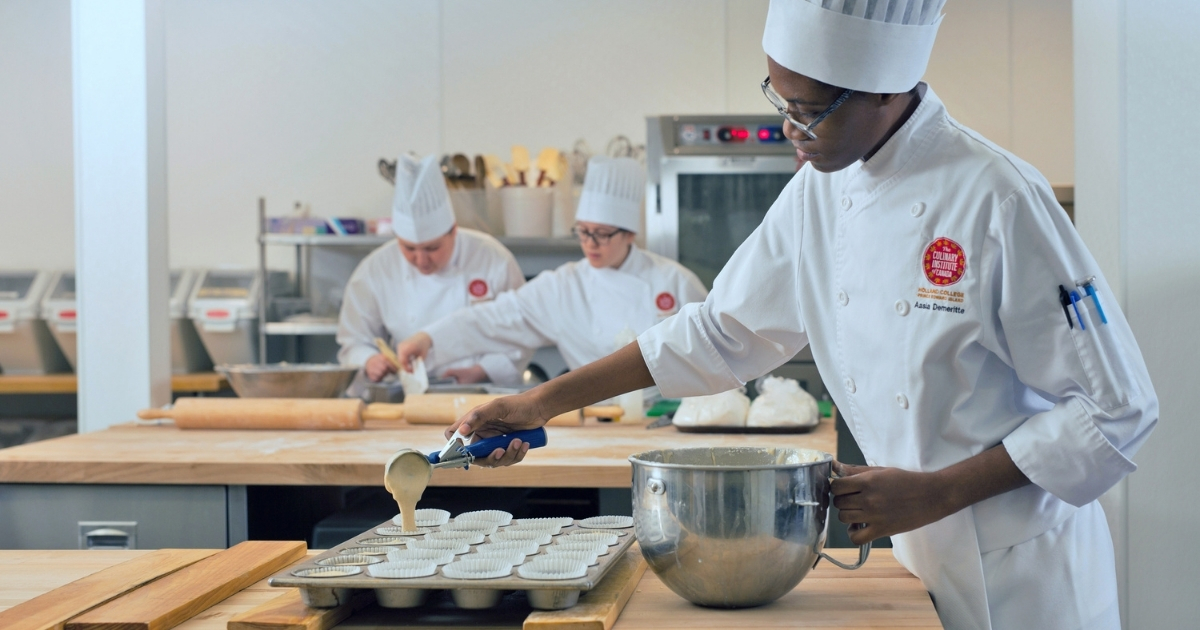 A student in chef whites portions batter into muffin tins in one of the kitchens at The Culinary Institute of Canada