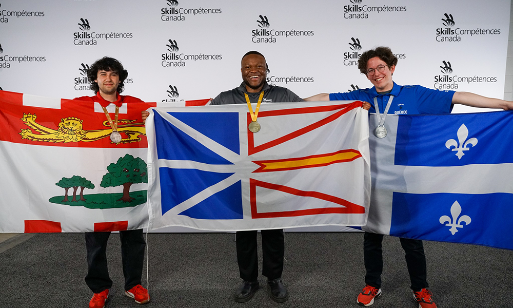 Matthew Gallant stands alongside recipients of gold and bronze awards. Each holds their provincial flag outstretched.