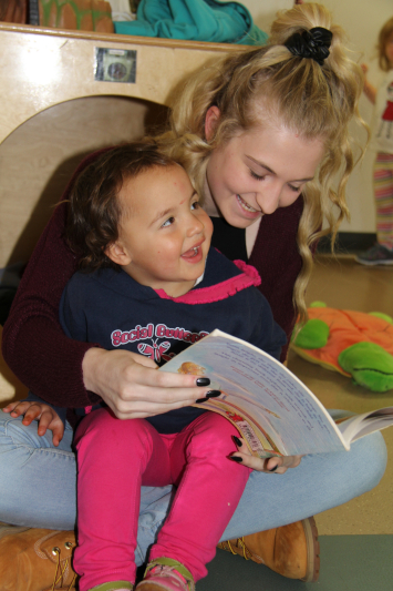 Student reading to small child