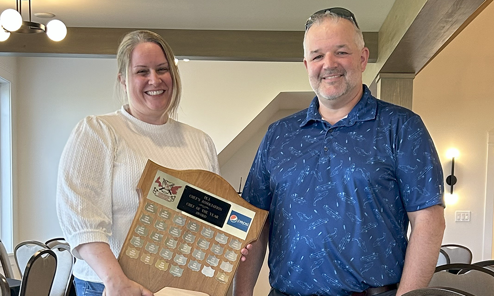Krista, left, accepts her awards plaque from CF PEI president Mark Gregory