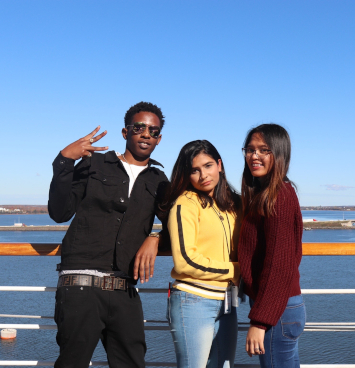 a group of students pose on the deck of a cruise ship docked in Charlottetown harbour